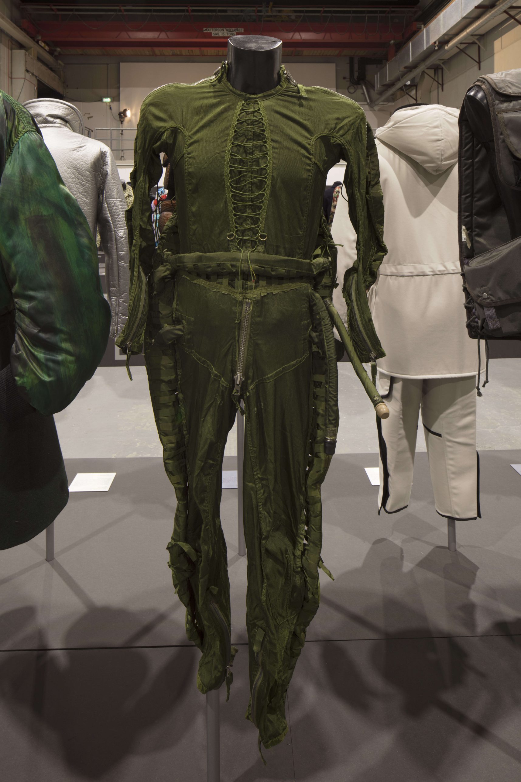 A digital image of a Chinese flight suit from the Westminster Menswear Archive, displayed on a mannequin as part of the Invisible Men exhibition at Ambika P3