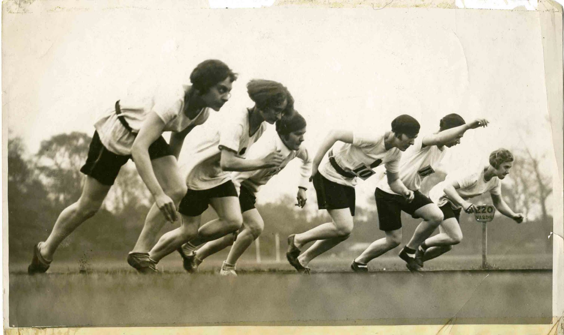 Dymanic black and white photograph showing women starting a running race in the 1930s