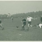 Black and white photo of men playing football