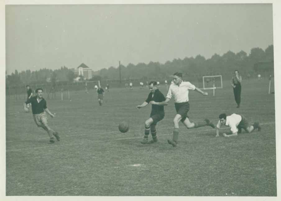 Black and white photo of men playing football
